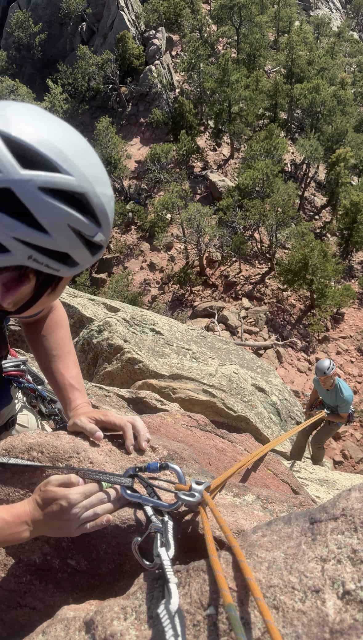 Trad climber belaying a partner during a multi-pitch climb in Boulder Canyon