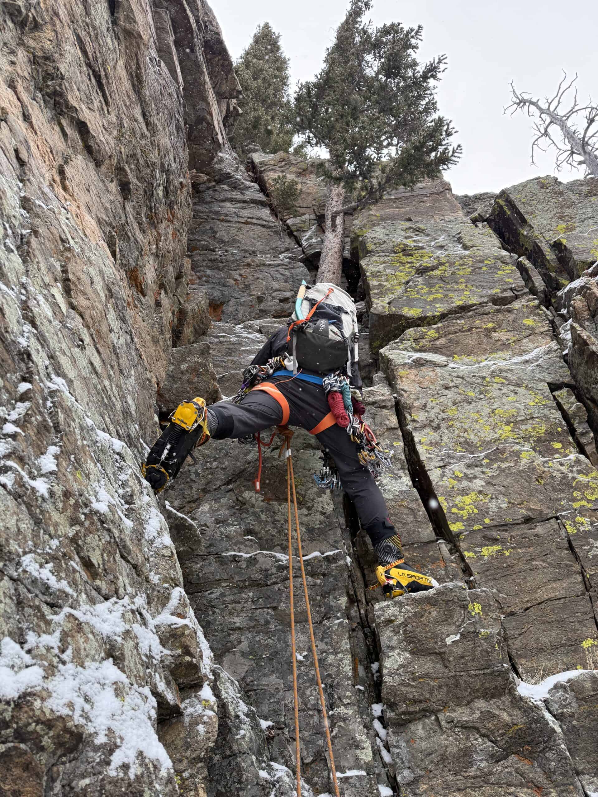 Climber bridging a rock chimney in crampons during a Basic Mountaineering Course